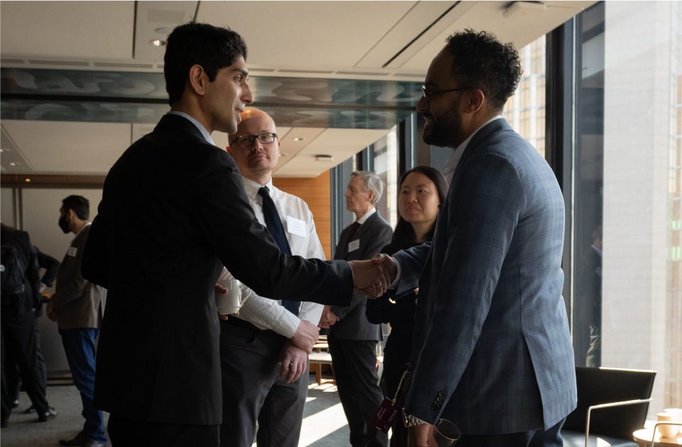 Two individuals shake hands and introduce themselves to each other at the INOVAIT Discovery Forum