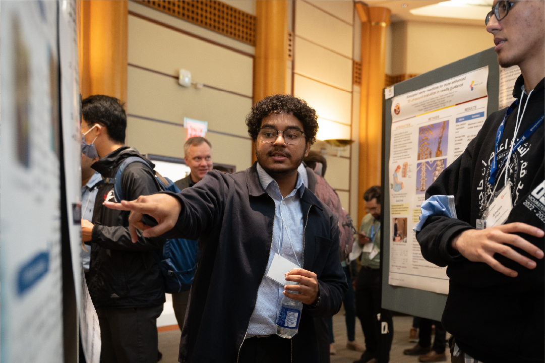 An IGT Symposium poster presenter presents their work to an attendee.
