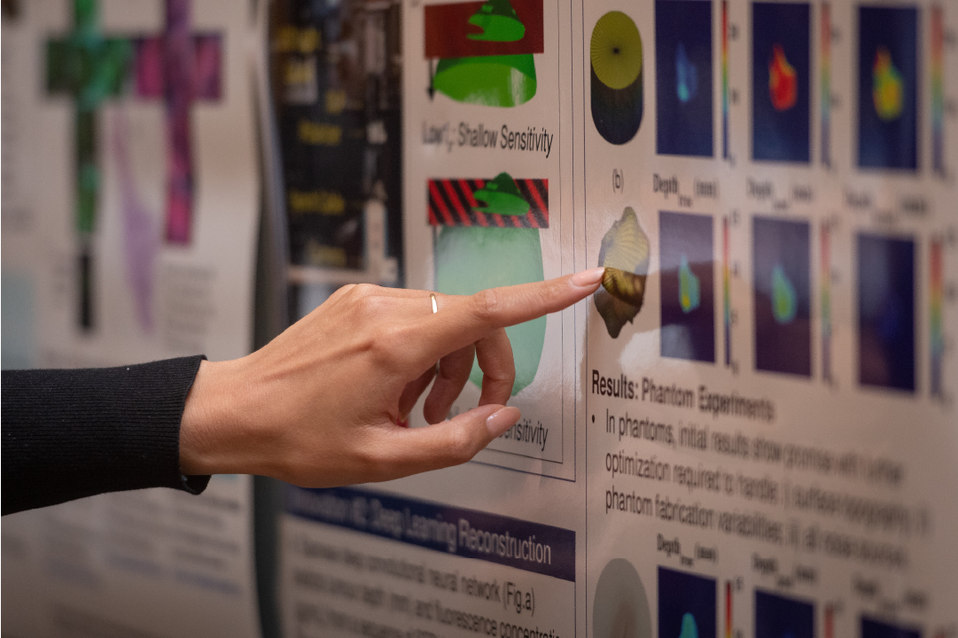 A finger points to a poster at the IGT Symposium.