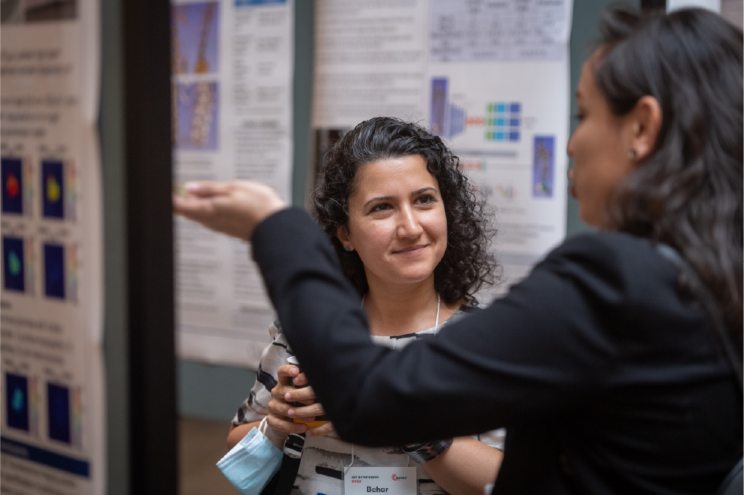 An IGT Symposium poster presenter presents their work to an attendee.