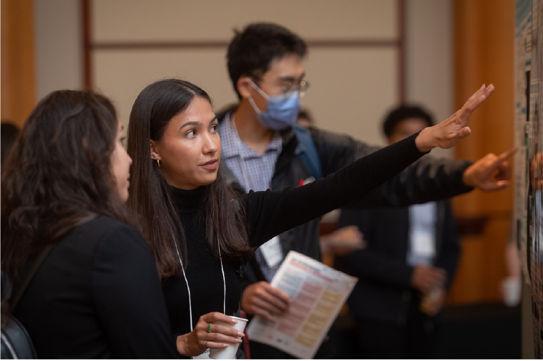 An IGT Symposium poster presenter presents their work to an attendee.