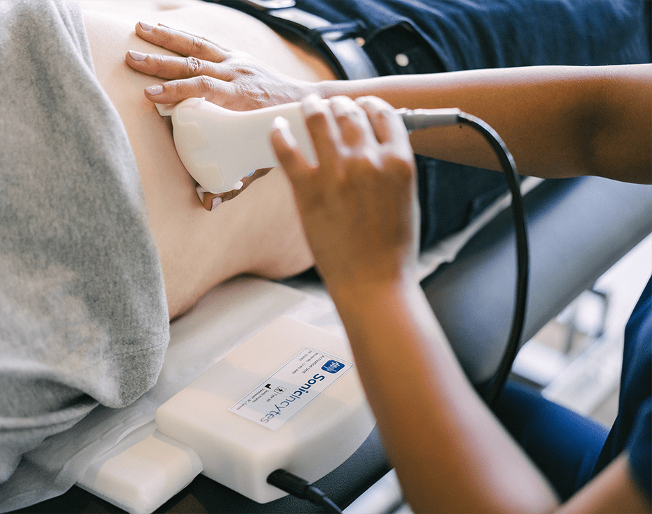 A close up of a healthcare professional using the Sonic Incites probe on a patient's stomach to screen for liver disease.